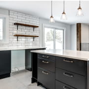 黒いキャビネットと白いタイルで装飾されたキッチンの画像